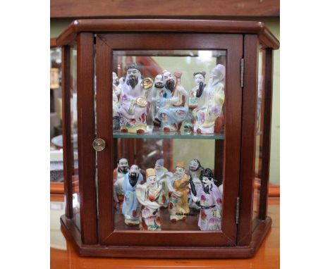 A table top display unit containing oriental ceramic figurines 