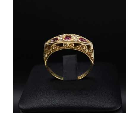 AN 18CT YELLOW GOLD RUBY AND DIAMOND DRESS RING. early 20th century, scrolled mount, open back setting, ring size M, complete