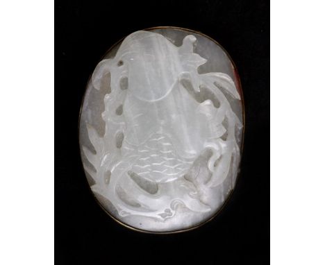 A Chinese carved jade brooch decorated with fruit and foliage, 6cms (2.25ins) wide.