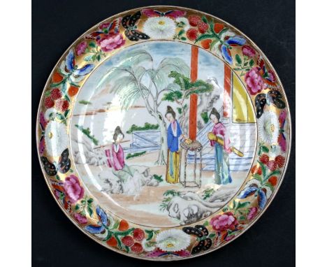 A 19th century Canton famille rose plate decorated with robed ladies making tea and playing the flute within a flower, fruit 