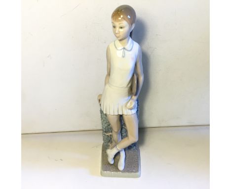 A Lladro figurine of a girl playing in a tennis outfit.