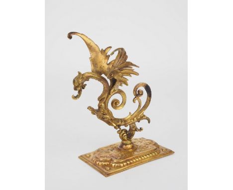 Barocker Taschenuhrenhalteraus Bronze, mit barocken Motiven verziert. Schwerer Stand rechteckig, seitlich profiliert, mittig 