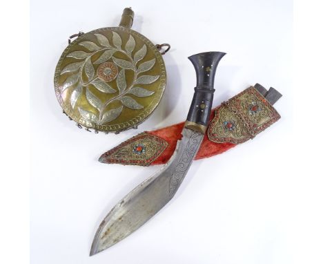 An Eastern ornate kukri knife with coral and turquoise set filigree mounts, and an Eastern brass moon-shaped powder flask (2)