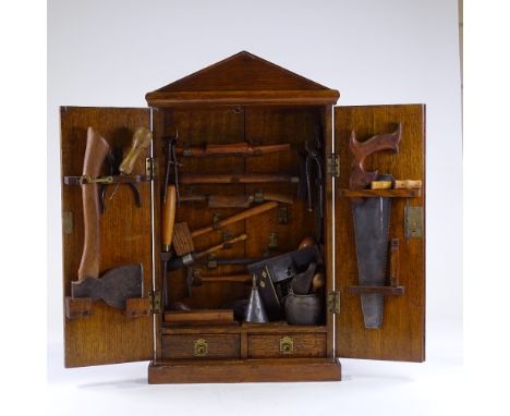 A Victorian panelled oak carpenter's tool cabinet, containing original tools, cabinet height 65cm, width 37cm 