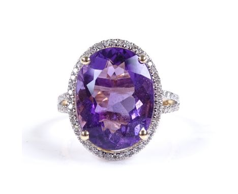 A 14ct gold amethyst and diamond halo cluster ring, with diamond set shoulders, oval-cut amethyst approx 6.92ct, total diamon