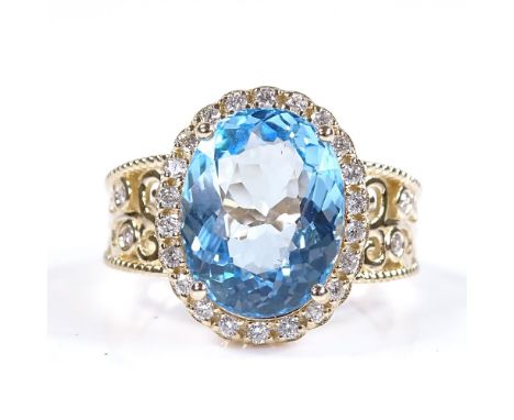 A 14ct gold blue topaz and diamond halo cluster ring, with diamond set pierced shoulders, oval-cut topaz approx 5.92ct, total