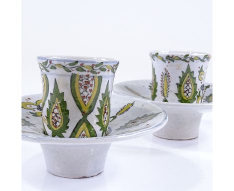 A pair of Turkish painted and glazed ceramic tea cups and saucers 