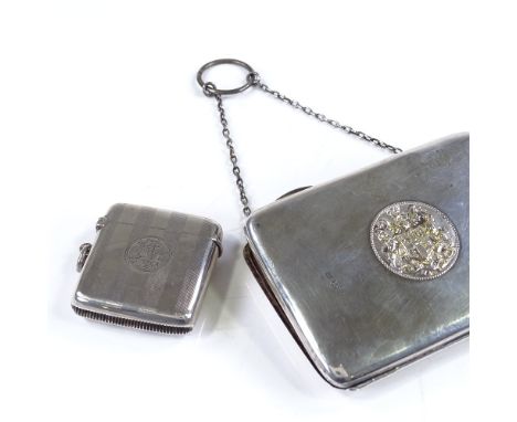 A rectangular silver evening purse, with central armorial, by Henry Williamson Ltd, hallmarks Birmingham 1911, together with 