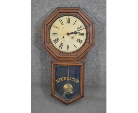 An early 20th century Oak cased "REGULATOR" wall clock, by Waterbury Clock Co., USA, enamel dial and brass pendulum and key. 