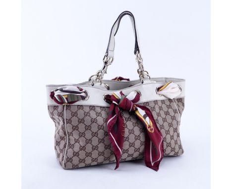 Gucci Beige Supreme Monogram Canvas And Leather Positano PM Tote. Gold tone hardware. The interior of brown fabric with zippe