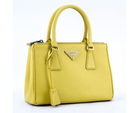 Prada Yellow Small Grained Leather Saffiano Lux Handbag. Silver tone hardware, the interior of signature fabric with zippered