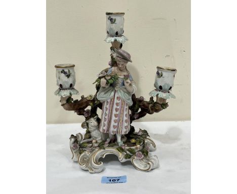 A 19th Century German porcelain figural three light candelabrum. 9¾" high. Damage, repairs.