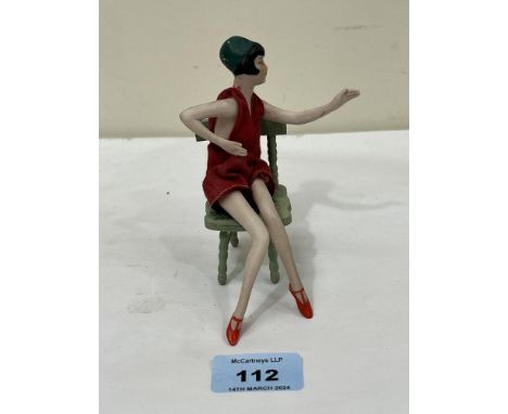 A 1920s bisque porcelain "boudoir lady" flapper doll with jointed limbs. 6" high approx. The lot to include a display chair.