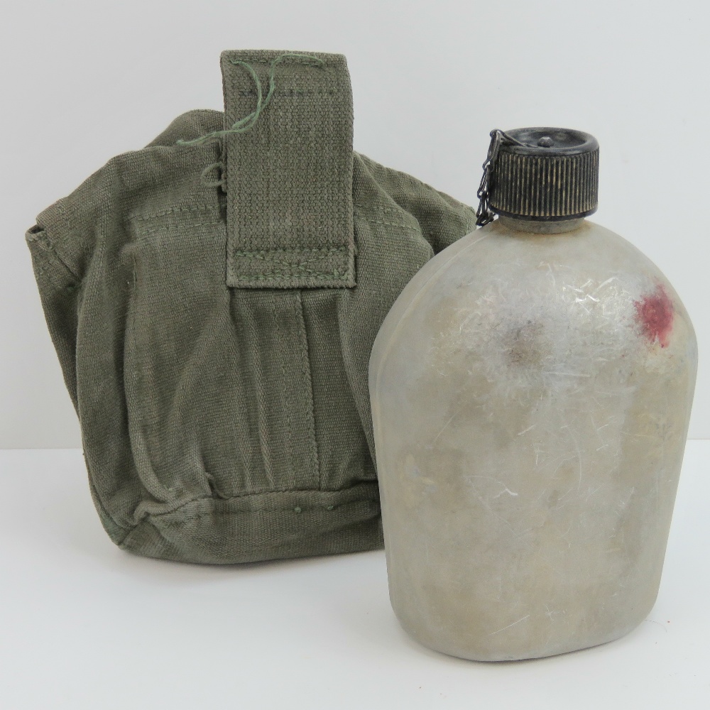 A WWII US water bottle with canvas slip.