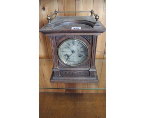 An oak mantle clock with a silvered dial striking on a gong - Height 28cm
