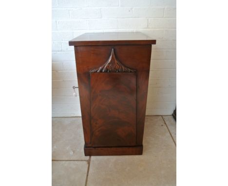 A flamed mahogany bedside cabinet with single panel door opening to reveal a shelf and drawer raised on plinth