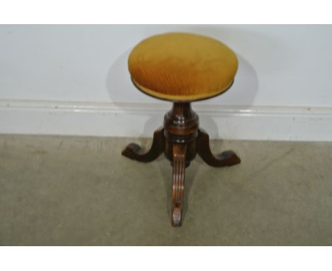 A mahogany revolving piano stool