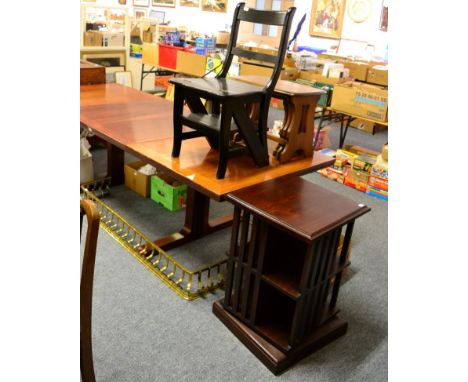 A revolving bookcase; brass fender; metamorphic library chair and a nest of three Ercol style tables 