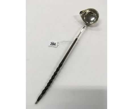 A  antique  white metal silver toddy ladle with whalebone twist handle.