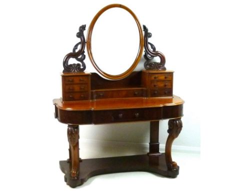 A Victorian mahogany dressing table, oval mirror, trinket drawers and carved front legs, with shaped undertier, 120 by 53 by 