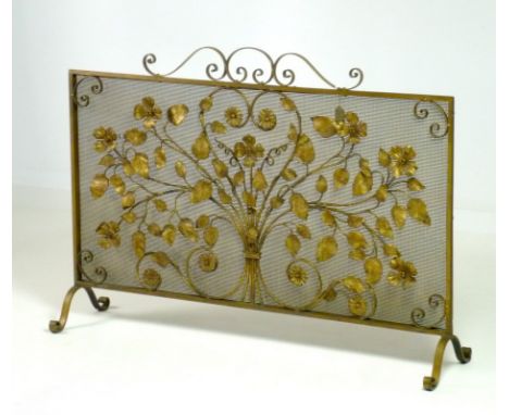 A wrought metal fire guard, circa 1940's, decorated with flowers against a mesh screen, 107 by 26 by 75cm high. 