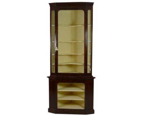 A late Victorian mahogany and brass mounted corner display cabinet, the outswept cornice over a single glazed door, with key,