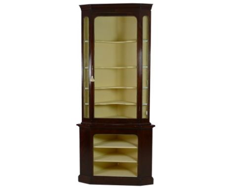 A late Victorian mahogany and brass mounted corner display cabinet, the outswept cornice over a single glazed door, with key,