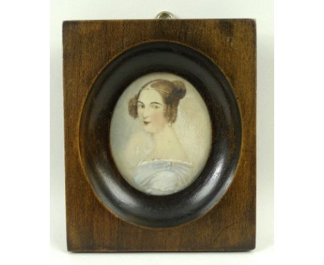 A portrait miniature of an early 19th century lady in a blue dress, her hair in ringlets and a bun sporting a jewelled head b