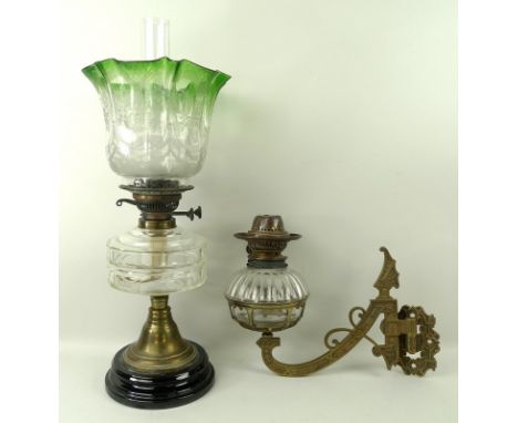 A Victorian oil lamp with clear faceted glass reservoir, etched green and clear glass shade and clear glass chimney, raised o