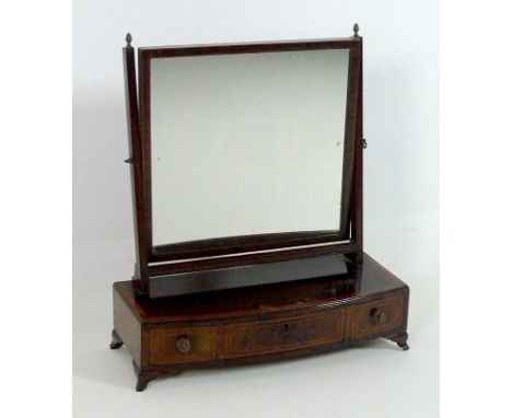 A Regency mahogany toilet mirror, with bowed crossbanded base, oak lined drawers, acorn brass finials, raised on curved brack