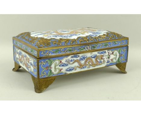 A Chinese enamel box and cover, with raised metal scroll border, mythical beasts to the corners, the reserve with a five toed