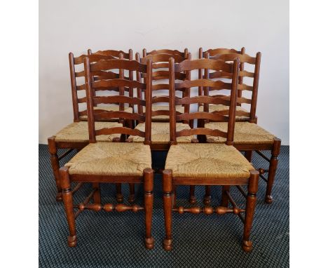 A good quality distressed oak reproduction oval gateleg table with a matching set of eight ladder back chairs with rush seat 