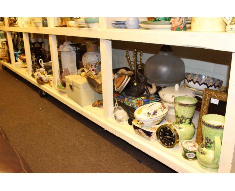 Full shelf of glass, china, mantel clocks, two Dalek models, chess set, ornaments, lamps, wicker basket, etc