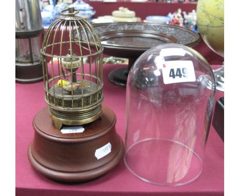 A Brass Musical Automaton Bird, in case in the XIX Century manner, 12.5cm high; together with wooden base and glass dome.