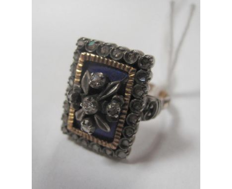 A XIX Century Style Diamond Set Ring, of rectangular design, highlighted in blue enamel, set to the centre with a brilliant c