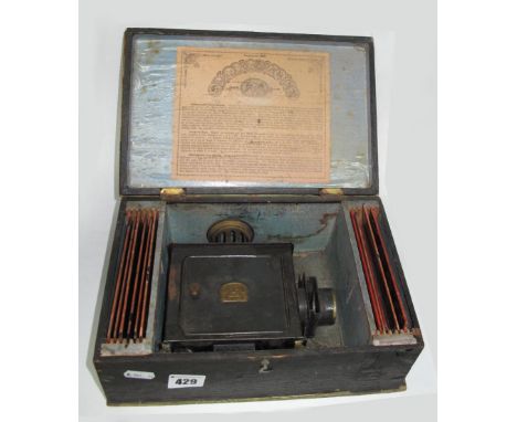 A German Magic Lantern, labelled 'E.P', with a quantity of long rectangular slides, in original box.