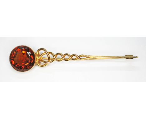 A Scottish provincial kilt pin, early 20th century, of twist form and terminating with a millegrain set round mixed cut orang