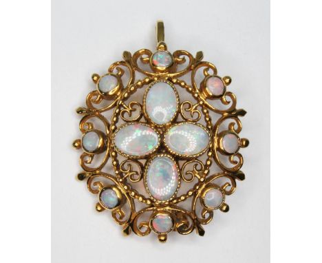 An opal pendant brooch, four central millegrain set oval opal cabochons surround by eight bezel set round opal cabochons with