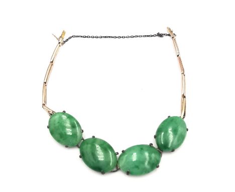 A yellow metal spring link and jade cabochon bracelet. Fastens with a hidden push clasp with safety catch and chain. (Two lin