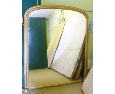 A VICTORIAN GILT FRAMED OVERMANTEL MIRROR, having moulded frame, on ceramic bun feet, plate size, 122cm x 95cm 