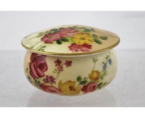 A ROYAL WORCESTER PORCELAIN SQUAT CIRCULAR TRINKET BOX with cover, hand painted floral decoration on a blush ivory ground, fa