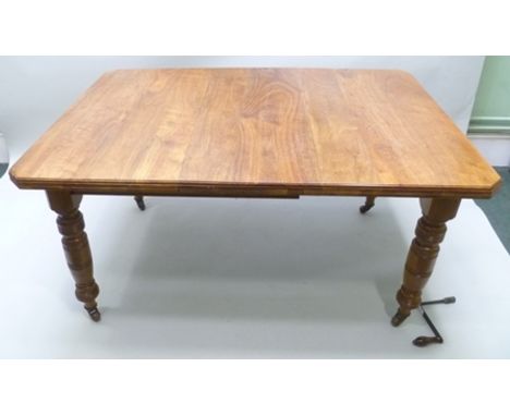 A LATE VICTORIAN WALNUT WIND OUT DINING TABLE having canted corners, wind out mechanism fitted one leaf, raised on ring turne