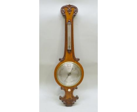 A 19TH CENTURY OAK FRAMED BAROMETER/THERMOMETER, having carved scroll decoration, the silvered calibrated dial engraved "Gard