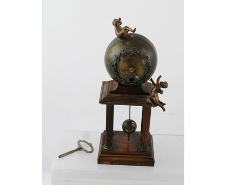 A "JUNGHANS" GLOBE MANTEL CLOCK, having a mahogany frame of four fluted columns supporting a brass globe with applied Arabic 