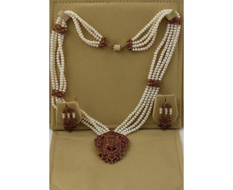 A RUBY AND FRESHWATER PEARL MOUNTED GILT METAL NECKLACE having ornate multi gem pendant on four strands of pearls, with match