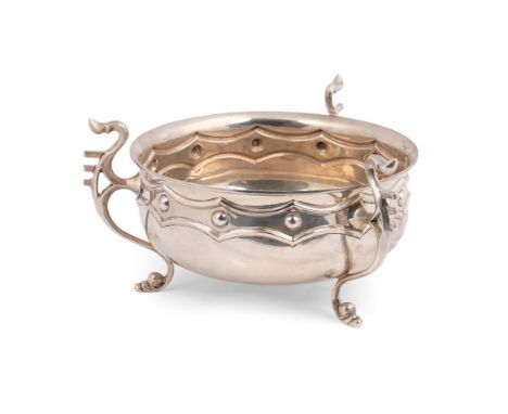 A large and impressive Edwardian Arts and Crafts silver bowl, of shallow cauldron form, with banded shield boss motifs, the t