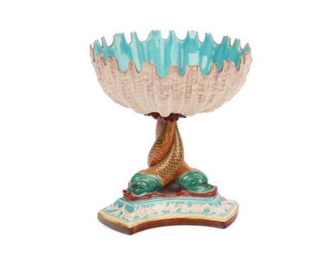 Royal Worcester majolica comport, raised on three dolphins, blue interior to bowl, shaped edge, impressed marks, 18.5cm tall.
