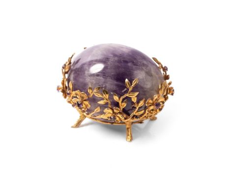 A carved amethyst egg in 9ct gold and amethyst set nest stand, modelled throughout as dog roses, or bramble flowers, each wit