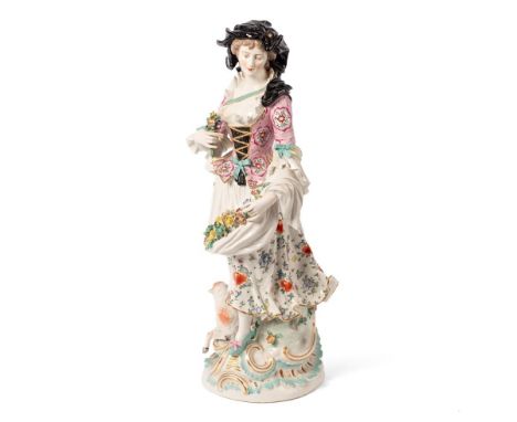 A 19th century continental large porcelain figurine of a lady in traditional dress holding a wealth of flowers, pink floral j