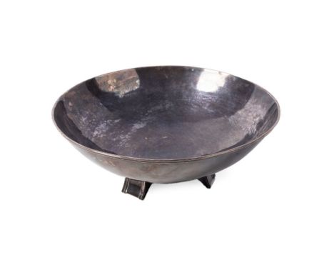 An artisanal silver bowl, in the Arts and Crafts style, of circular form with planished finish, reeded rim and raised on thre